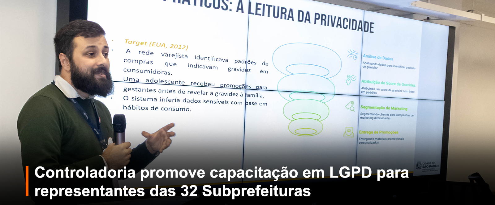 Fotografia de apresentação: homem com microfone à esquerda. À direita, tela dividida em quatro monitores exibe 